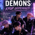 Un groupe K-Pop en performance, sur scène avec des lumières sombres accentuant une ambiance mélancolique.