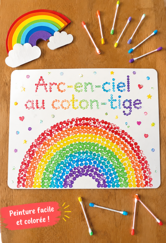 Arc-en-ciel coloré réalisé avec des cotons-tiges et présenté sur une table.
